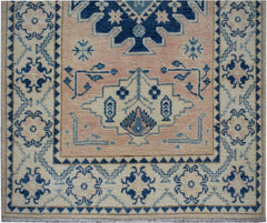 Handmade Afghan Kazakh runner featuring a geometric floral pattern in blue on a beige background.