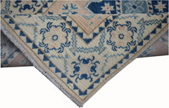 A handmade Afghan Kazakh runner featuring a geometric pattern in blue and beige wool.