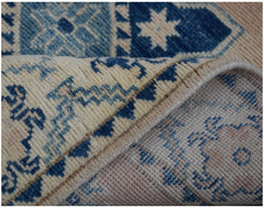 A handmade Afghan Kazakh runner rug featuring a geometric blue and beige pattern.