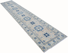 An Afghan Kazakh runner rug featuring a beige background with blue geometric patterns.