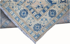 A handmade Afghan Kazakh runner rug featuring a geometric pattern in shades of blue and beige.