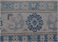 A handmade Afghan Kazakh runner featuring a geometric floral pattern in blue and beige tones.