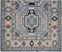 Handmade Afghan Kazakh runner rug featuring a geometric medallion pattern in blue and beige.