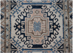 An Afghan Kazakh runner rug featuring a geometric medallion pattern in beige, blue, and grey.