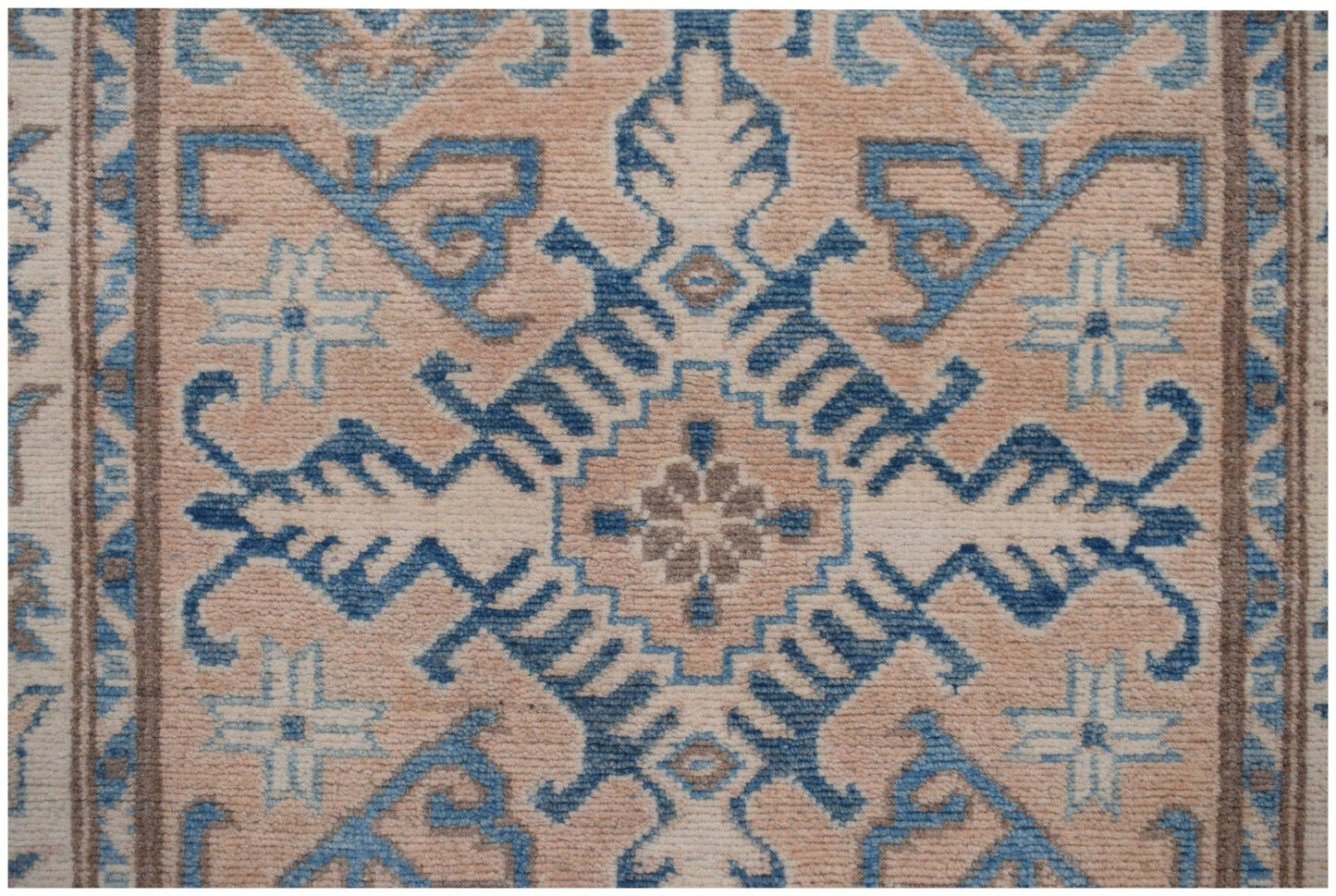 A handmade Afghan Kazakh runner featuring a geometric blue and beige tribal pattern.