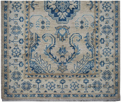 Handmade Afghan Kazakh runner rug featuring a traditional blue and beige geometric pattern.