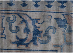 A close-up of a handmade Afghan Kazakh runner featuring intricate blue floral patterns on beige.