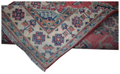 An Afghan Kazakh runner rug featuring traditional geometric motifs in red, blue, and cream.