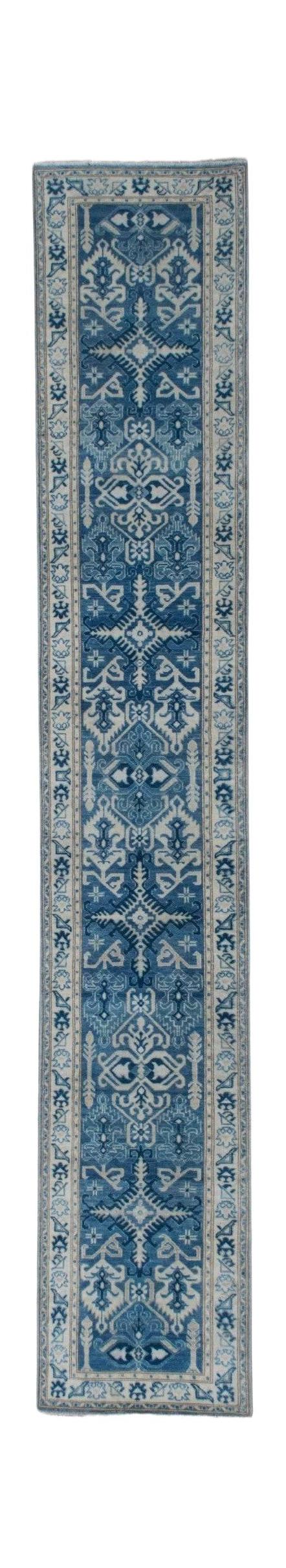 A handmade Afghan Kazakh runner rug featuring a geometric pattern in shades of blue and beige.