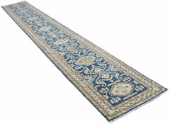 A long, handmade Afghan Kazakh runner rug featuring a blue field with intricate beige patterns.