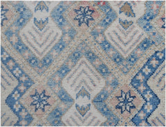 An Afghan Kazakh runner rug featuring a geometric diamond pattern in shades of blue, beige, and pink.