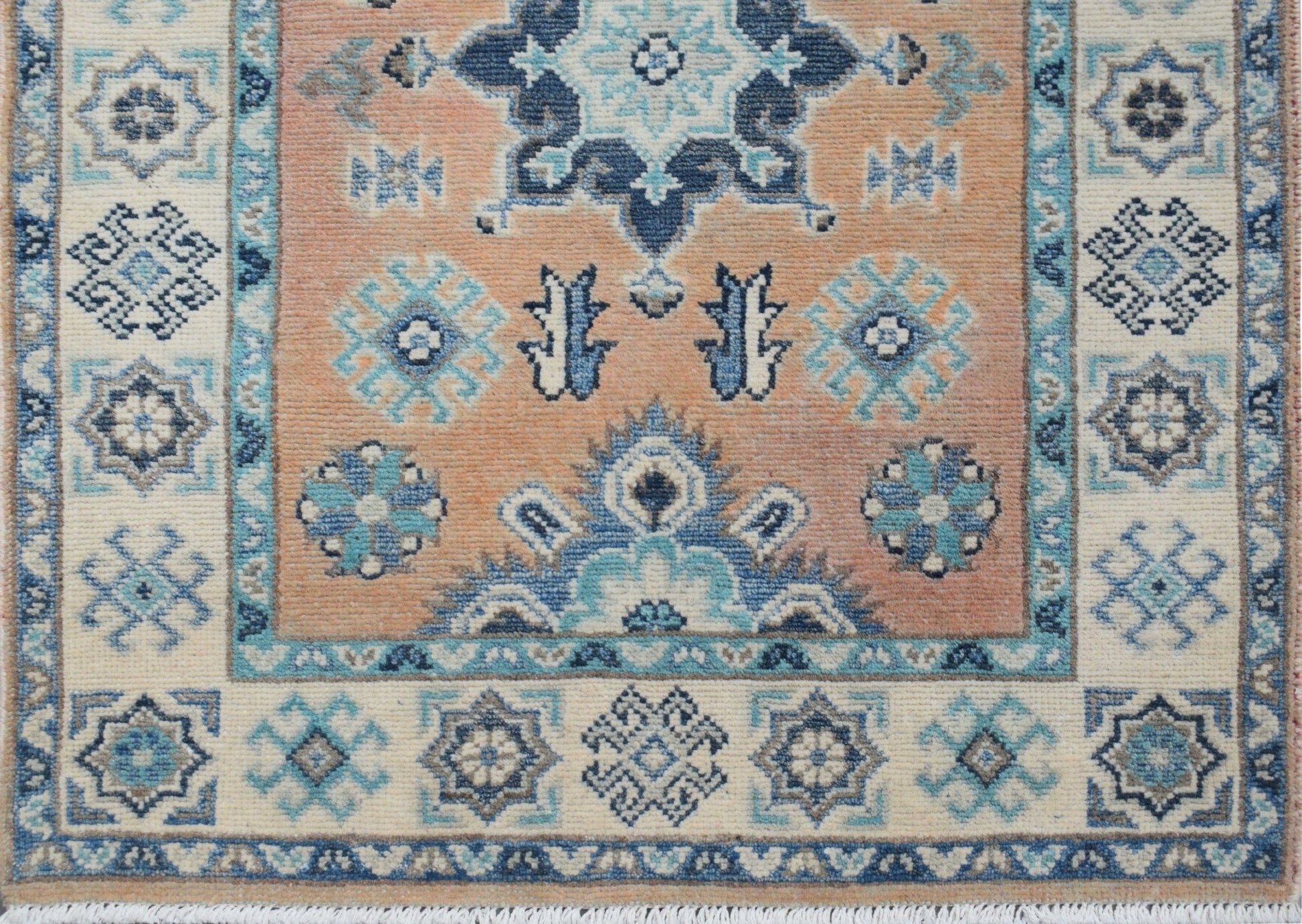 Handmade Afghan Kazakh runner featuring a geometric floral pattern in blue, beige, and grey.