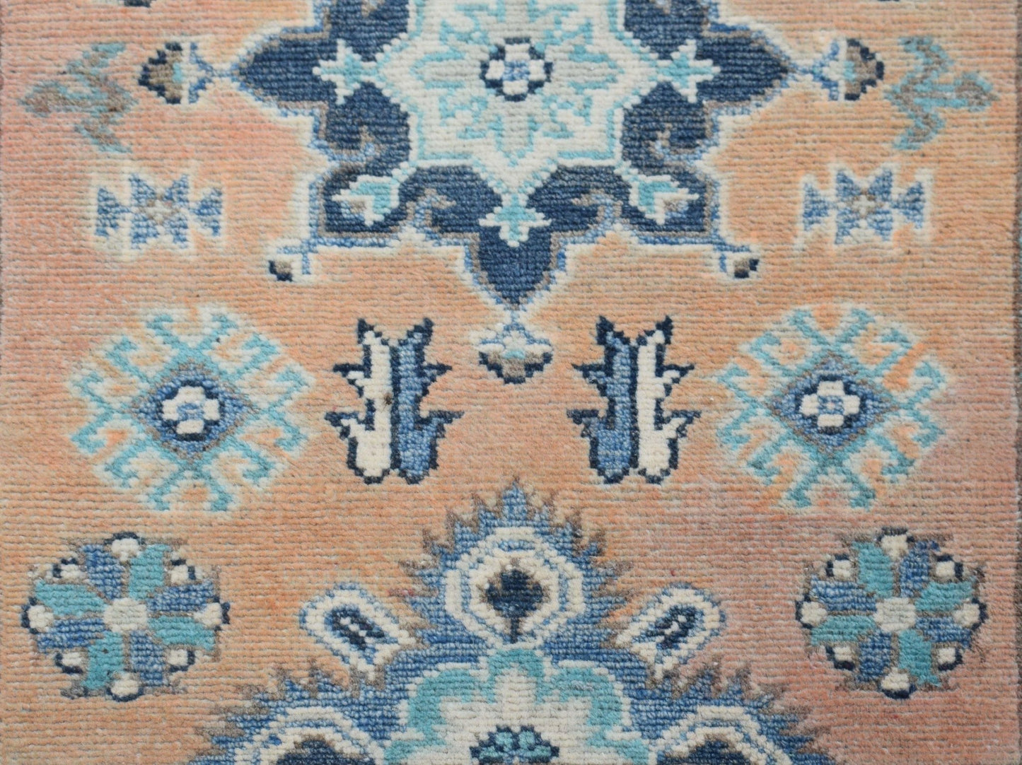 Handmade Afghan Kazakh runner featuring a geometric floral pattern in shades of blue and beige.