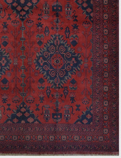 Handmade Afghan Khal Mohammadi wool rug featuring a deep red field with dark blue geometric motifs.