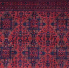 Handmade Afghan Khal Mohammadi rug featuring a deep red field with repeating blue geometric motifs.