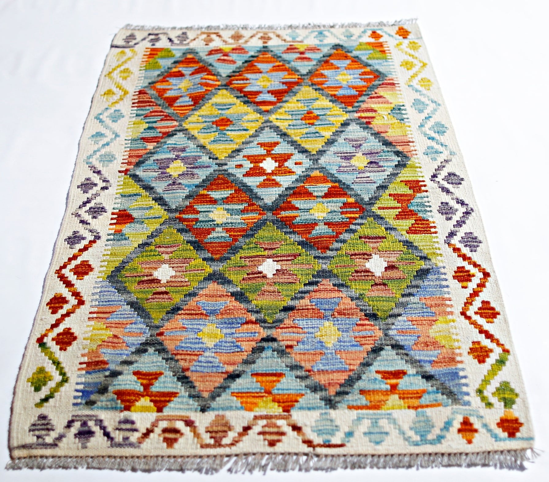 Handwoven Afghan Maimana kilim rug featuring a colorful geometric diamond pattern.