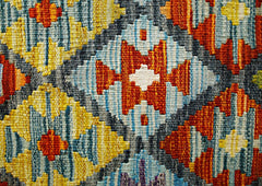 A close-up of a handmade Afghan Maimana kilim featuring a vibrant geometric diamond pattern.