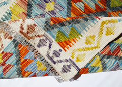 A handwoven Afghan Maimana kilim rug featuring a vibrant geometric pattern in wool.