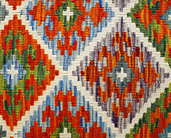 Handwoven Afghan Maimana kilim featuring a vibrant geometric diamond pattern in wool.