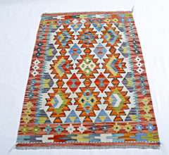 Handwoven Afghan Maimana kilim rug featuring a vibrant geometric pattern in wool.