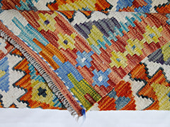 A handmade Afghan Maimana kilim featuring a vibrant geometric pattern in wool.