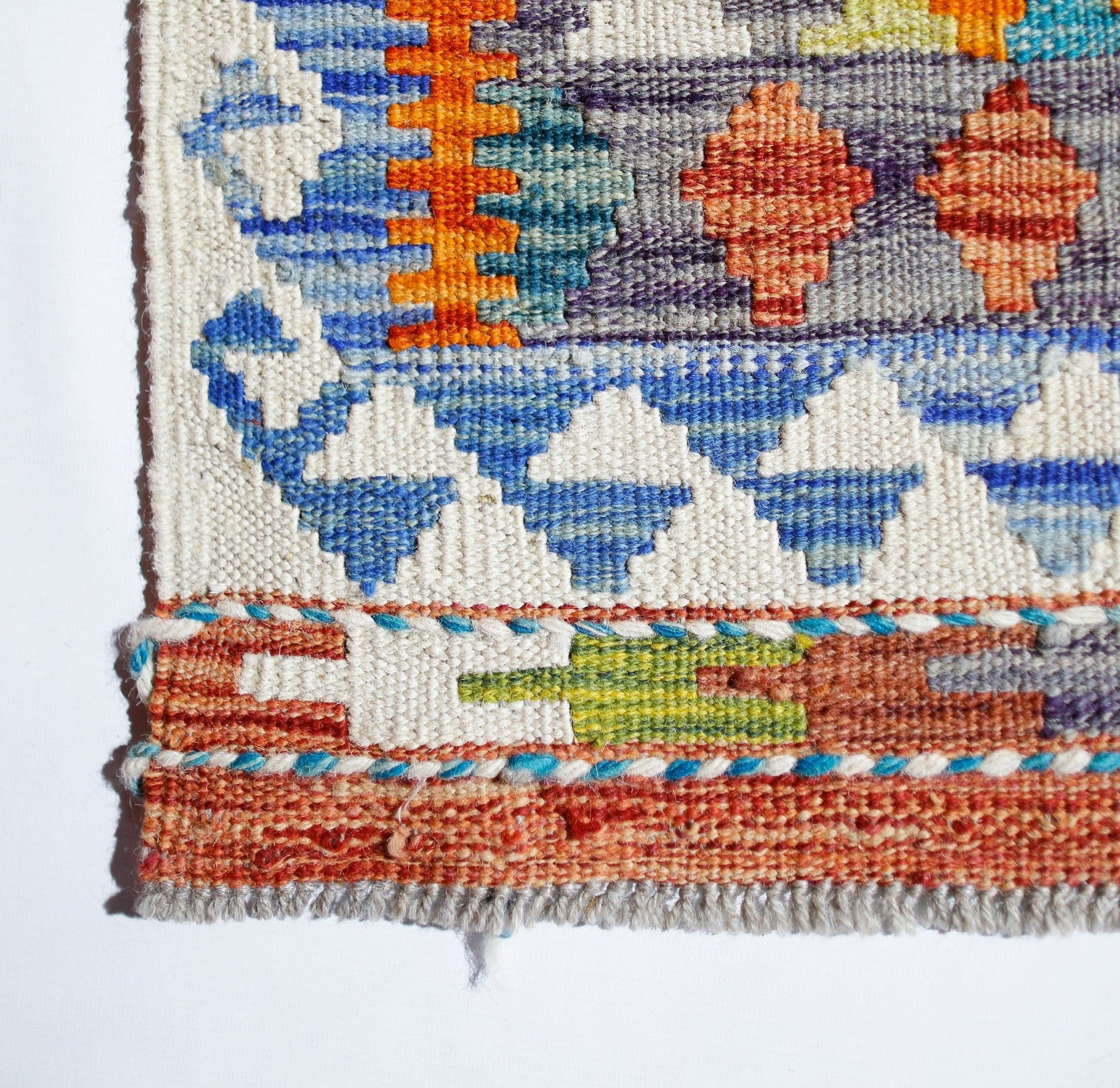 Handwoven Afghan Maimana kilim featuring a geometric pattern in vibrant orange, blue, and green.