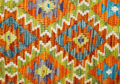 A handmade Afghan Maimana kilim featuring a vibrant geometric pattern in orange, blue, and green.