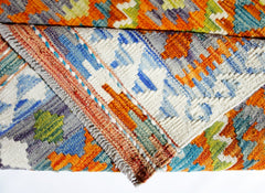 A handmade Afghan Maimana kilim rug featuring a vibrant geometric pattern in wool.