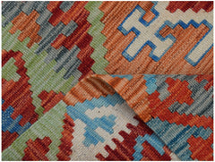 A handmade Afghan Maimana kilim rug featuring a geometric pattern in vibrant red, blue, and green.