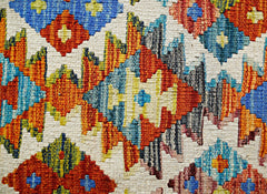 Handwoven Afghan Maimana kilim featuring a vibrant geometric pattern in wool.