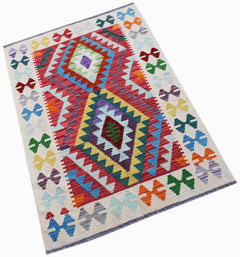 Handwoven Afghan Maimana kilim rug featuring a colorful geometric diamond pattern on a cream base.