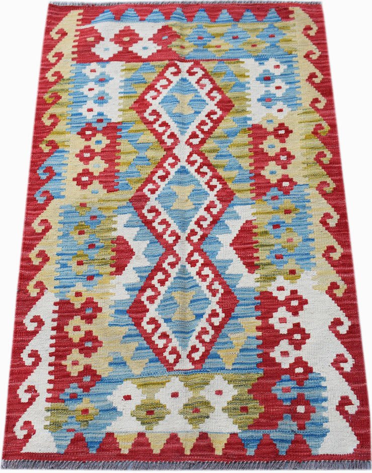 Handwoven Afghan Maimana kilim rug featuring a geometric diamond pattern in red, blue, and yellow.