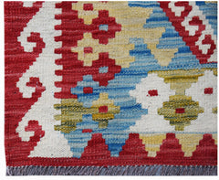 Handwoven Afghan Maimana kilim rug featuring a geometric pattern in red, blue, and yellow wool.