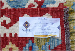 A close-up of a handmade Afghan Maimana Kilim featuring a vibrant geometric pattern in wool.