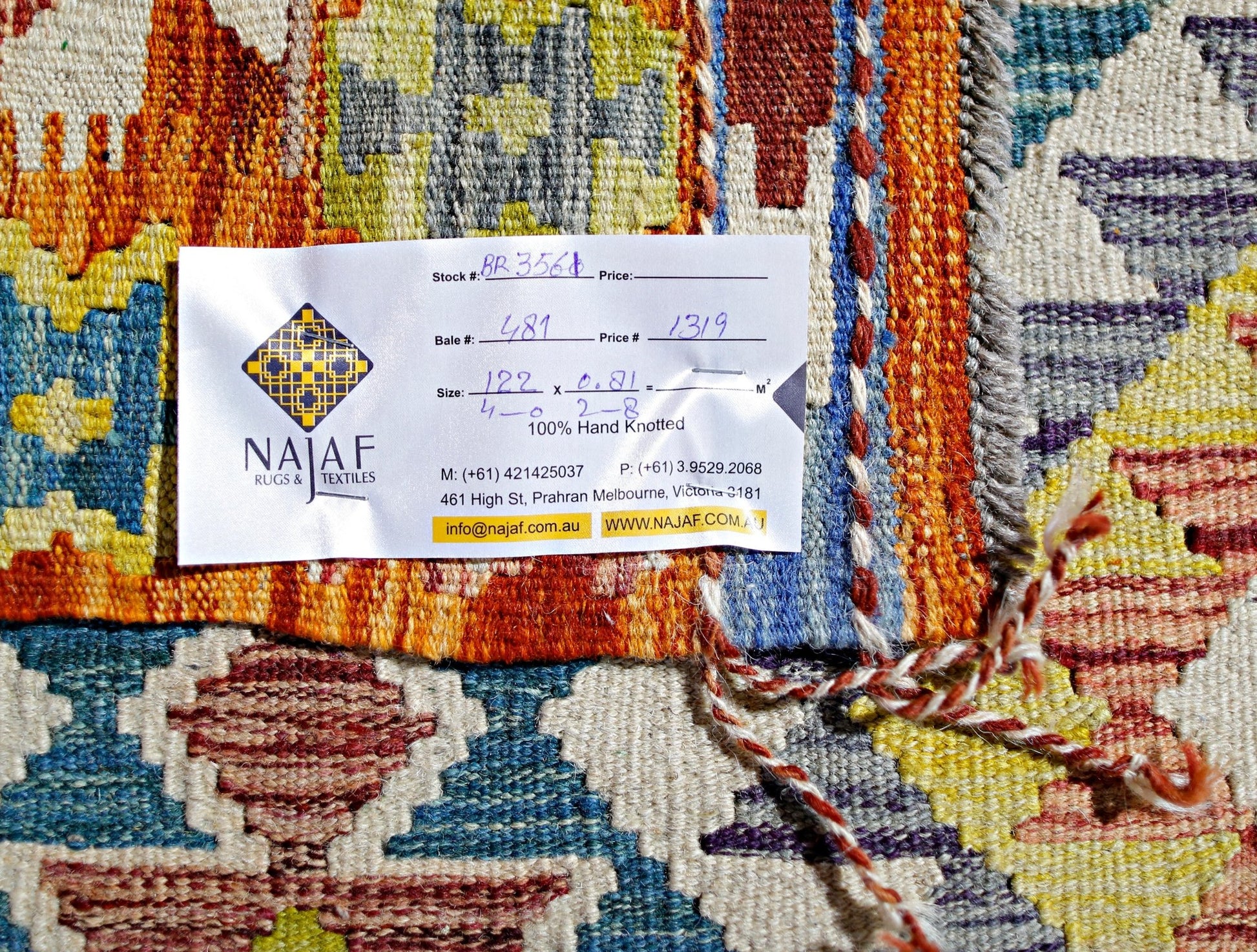 A handwoven Afghan Maimana kilim rug featuring a vibrant geometric pattern in wool.
