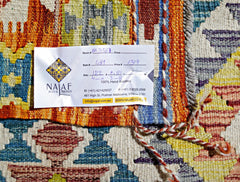 A handwoven Afghan Maimana kilim rug featuring a vibrant geometric pattern in wool.