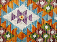 Handwoven Afghan Maimana kilim featuring a vibrant geometric pattern in wool.