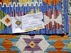 A handwoven Afghan Maimana kilim featuring vibrant geometric patterns in blue, orange, and purple.