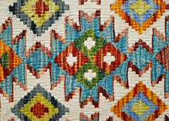 Handwoven Afghan Maimana kilim featuring a vibrant geometric pattern in wool.