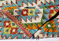 A handwoven Afghan Maimana kilim rug featuring vibrant geometric patterns in wool.