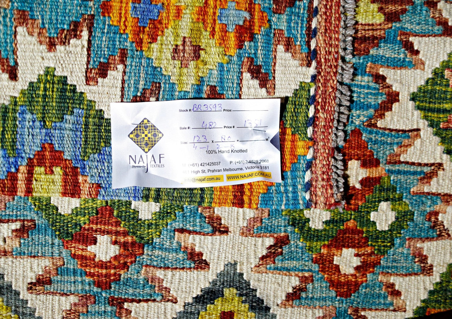 A handwoven Afghan Maimana kilim featuring a vibrant geometric pattern in wool.