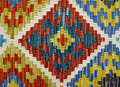 Handwoven Afghan Maimana kilim featuring a vibrant geometric pattern in red, blue, and yellow.