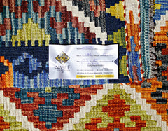 Handwoven Afghan Maimana Kilim rug featuring a vibrant geometric pattern in wool.