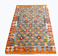 Handwoven Afghan Maimana kilim rug featuring a geometric pattern in vibrant orange and blue tones.