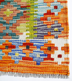 Handwoven Afghan Maimana kilim rug featuring a vibrant geometric pattern in wool.