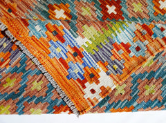 A handmade Afghan Maimana kilim rug featuring a vibrant geometric pattern in wool.