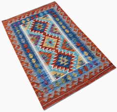 Handwoven Afghan Maimana kilim rug featuring a geometric pattern in blue, orange, and yellow.