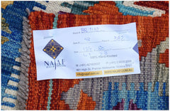 A close-up of a handwoven Afghan Maimana Kilim featuring vibrant geometric patterns in wool.