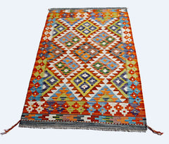 A rectangular Afghan Maimana kilim featuring a vibrant, multi-colored geometric diamond pattern.