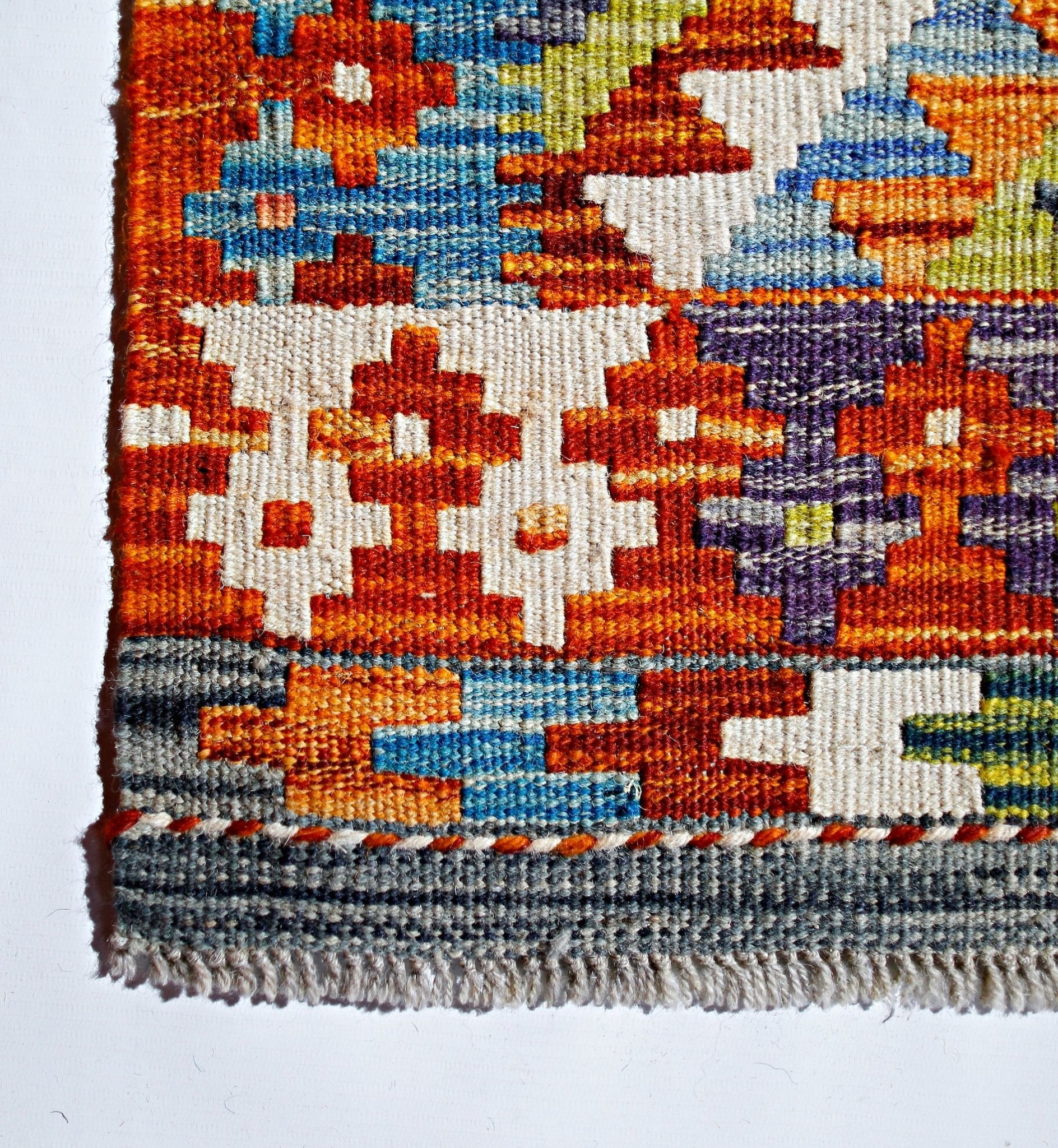 Handwoven Afghan Maimana kilim featuring a vibrant geometric pattern in wool.